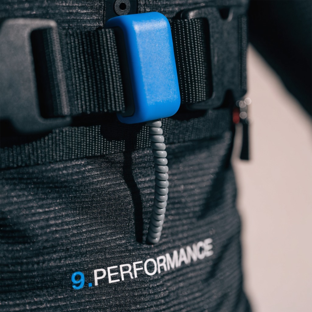 Close-up of an EMS module clipped onto the suit's webbing strap